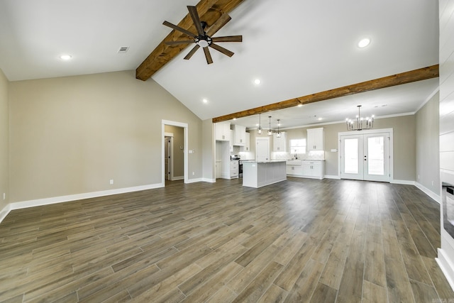 unfurnished living room featuring dark wood-type flooring, visible vents, baseboards, and ceiling fan with notable chandelier