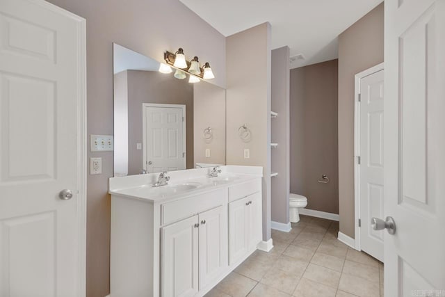 bathroom with double vanity, tile patterned flooring, a sink, and toilet