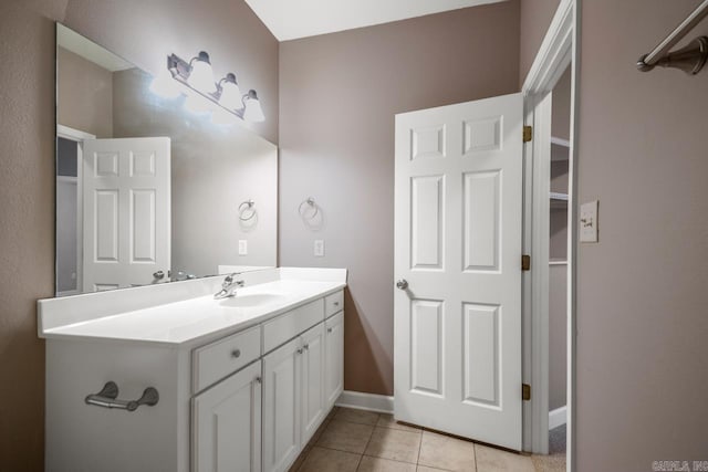 bathroom with baseboards, vanity, and tile patterned floors