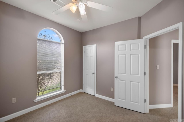unfurnished bedroom featuring a ceiling fan, carpet flooring, visible vents, and baseboards