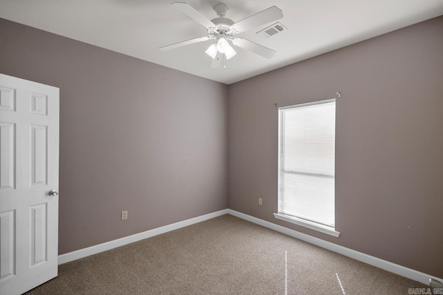 carpeted empty room with visible vents, baseboards, and ceiling fan