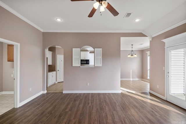 unfurnished living room with visible vents, crown molding, baseboards, and wood finished floors