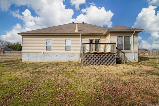 rear view of house featuring a deck and a yard