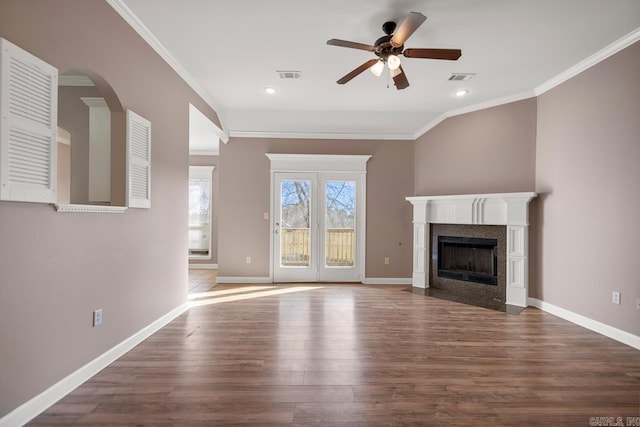 unfurnished living room with visible vents, crown molding, baseboards, and wood finished floors