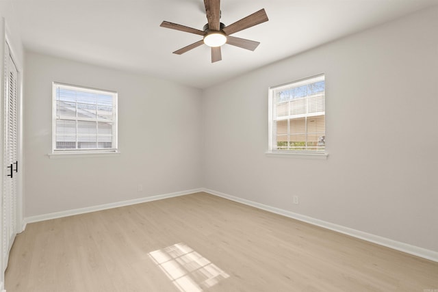 unfurnished bedroom with light wood-type flooring, a ceiling fan, baseboards, and a closet