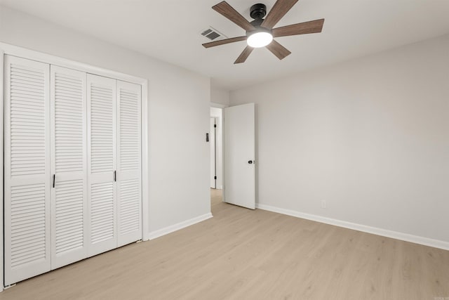 unfurnished bedroom with baseboards, visible vents, a ceiling fan, light wood-style floors, and a closet