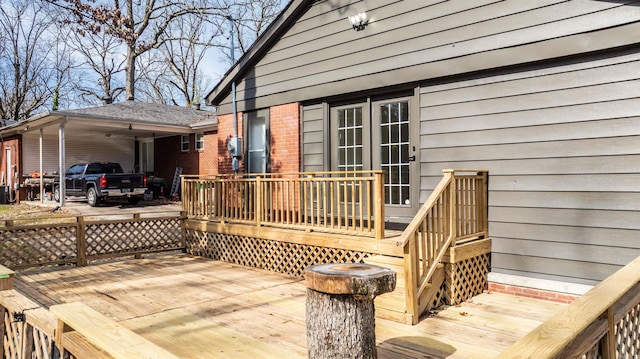 wooden deck featuring a carport and concrete driveway