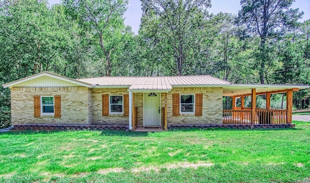 single story home with a front yard, brick siding, and metal roof