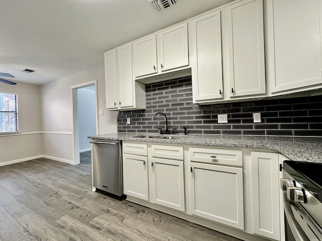 kitchen featuring stainless steel appliances, a sink, visible vents, white cabinets, and light wood-type flooring