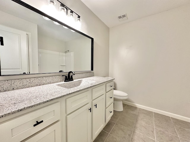 bathroom with toilet, vanity, visible vents, baseboards, and walk in shower