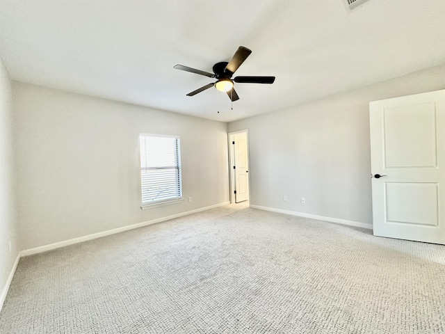 empty room featuring baseboards, ceiling fan, and light colored carpet