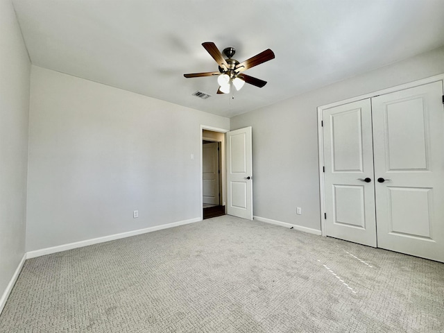 unfurnished bedroom with a closet, visible vents, light carpet, and baseboards