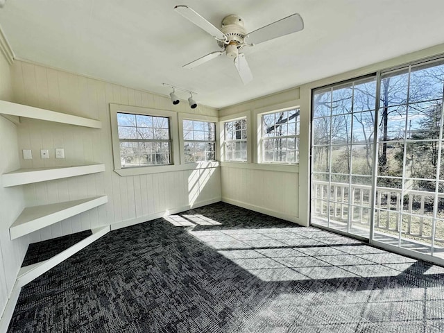 unfurnished sunroom featuring a ceiling fan and track lighting