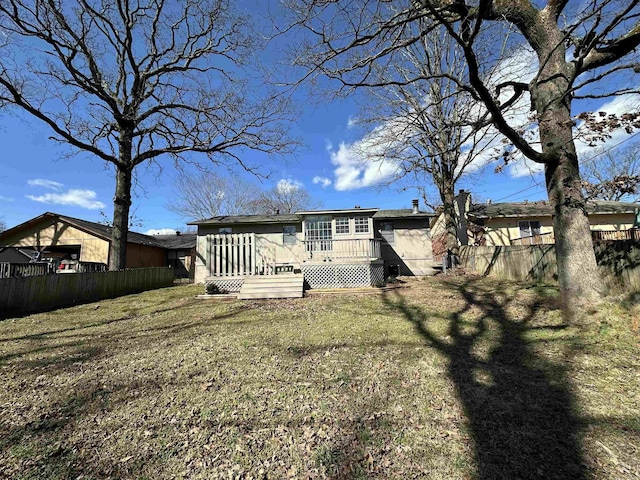 back of property with fence private yard, a lawn, and a deck