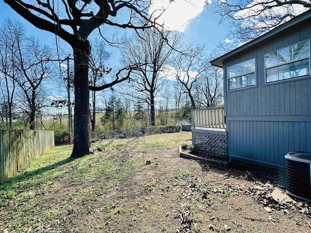 view of yard featuring central AC unit and fence