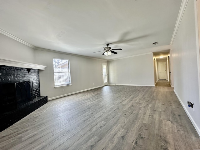 unfurnished living room featuring ceiling fan, a fireplace, ornamental molding, and wood finished floors