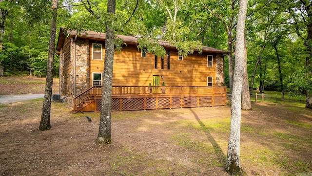 view of side of home with stone siding, stairs, and a wooden deck