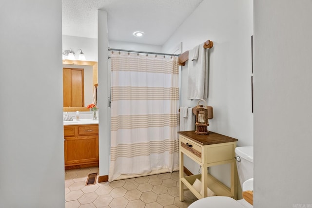 bathroom with toilet, a textured ceiling, a shower with shower curtain, and vanity