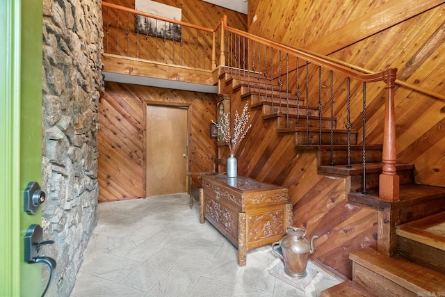 stairway featuring wooden walls