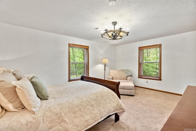 carpeted bedroom featuring baseboards, a textured ceiling, visible vents, and an inviting chandelier