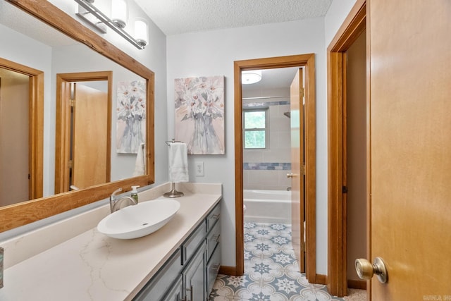 bathroom with washtub / shower combination, baseboards, a textured ceiling, and vanity