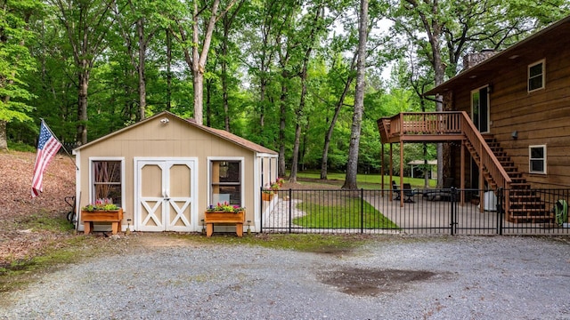 view of shed with stairway and fence