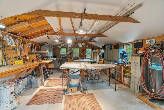 misc room featuring vaulted ceiling, concrete floors, and a workshop area