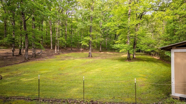 view of yard with fence and a forest view