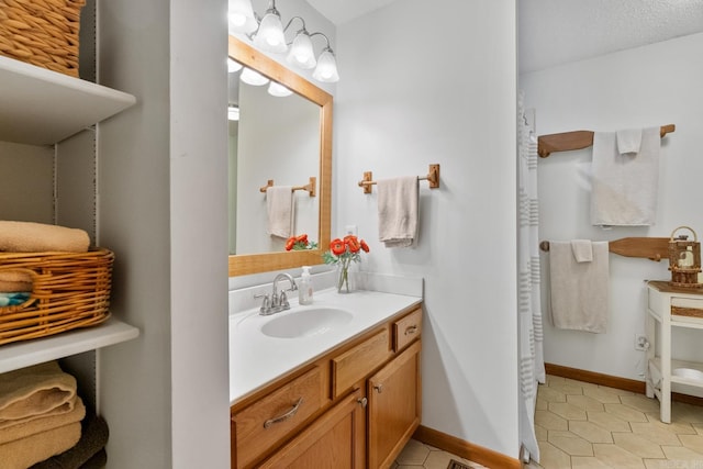 bathroom featuring baseboards, vanity, and tile patterned floors