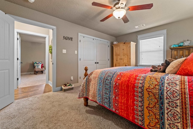 bedroom with carpet floors, baseboards, visible vents, and a textured ceiling