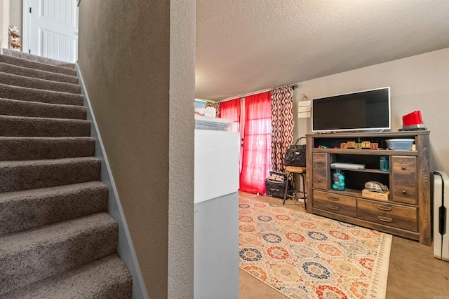 stairs with a textured ceiling, a textured wall, and tile patterned flooring