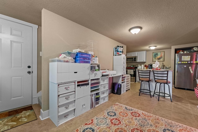 home office featuring a textured ceiling and light tile patterned floors