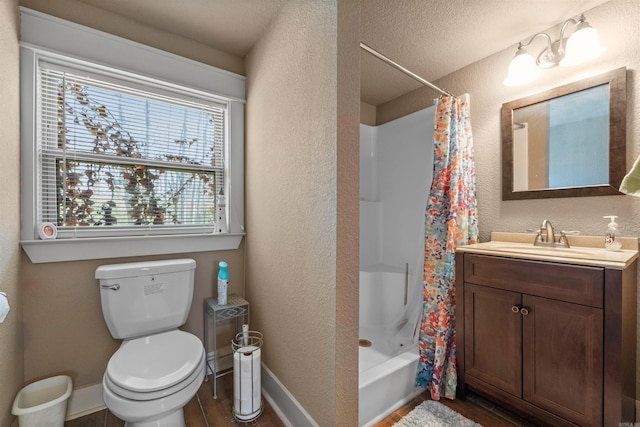 bathroom with baseboards, a textured wall, toilet, and wood finished floors