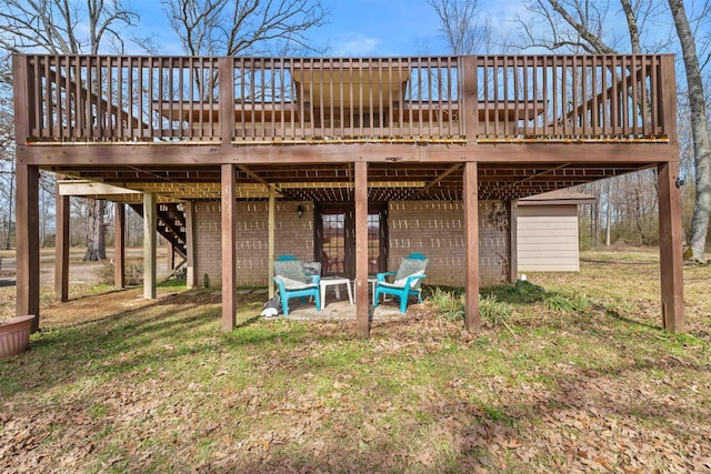 rear view of property with a yard, brick siding, stairway, and a wooden deck