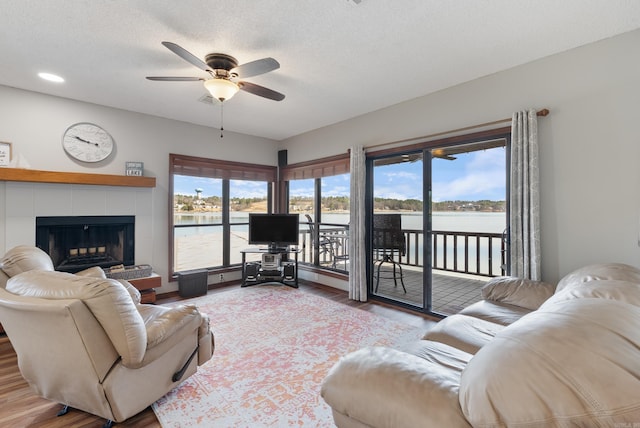 living room featuring a textured ceiling, wood finished floors, and a tile fireplace