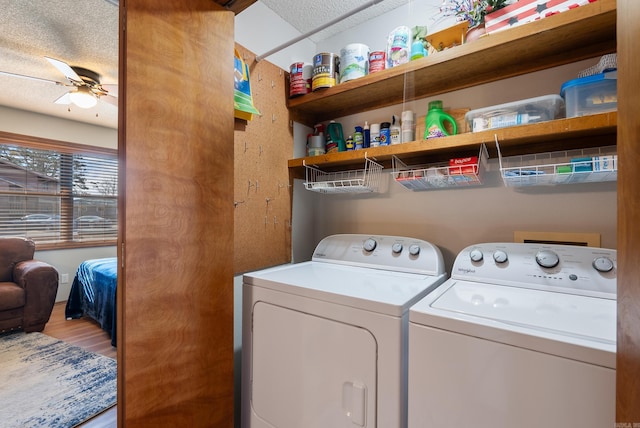 laundry area featuring a ceiling fan, laundry area, washing machine and clothes dryer, and wood finished floors