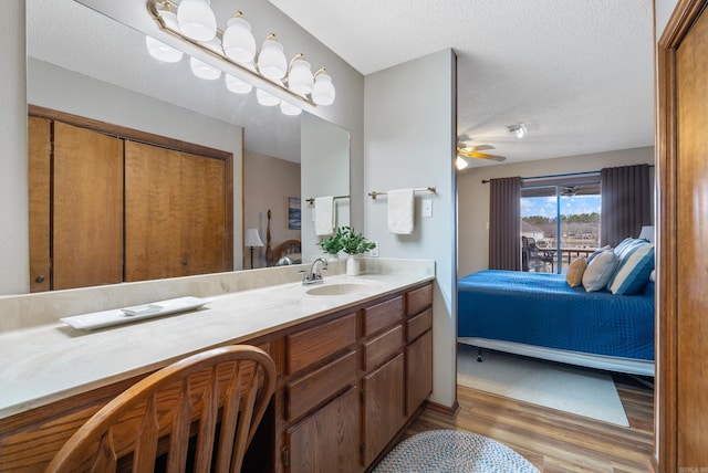 bathroom with ensuite bathroom, a textured ceiling, and wood finished floors