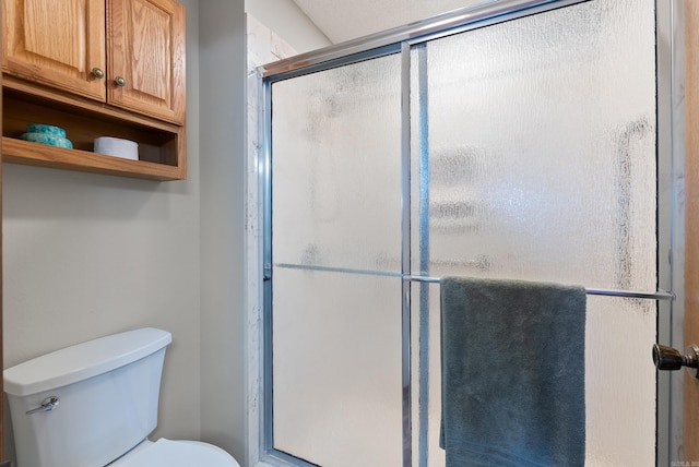 bathroom featuring a shower stall and toilet