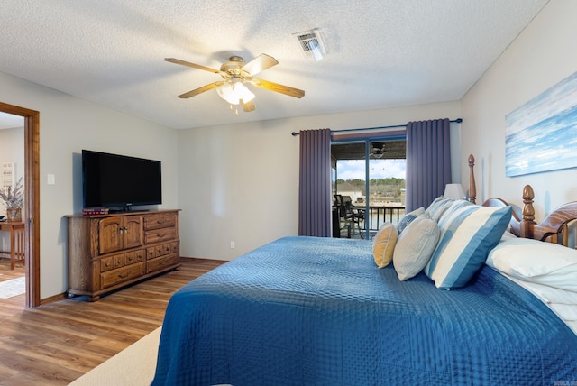 bedroom with visible vents, ceiling fan, a textured ceiling, wood finished floors, and access to outside