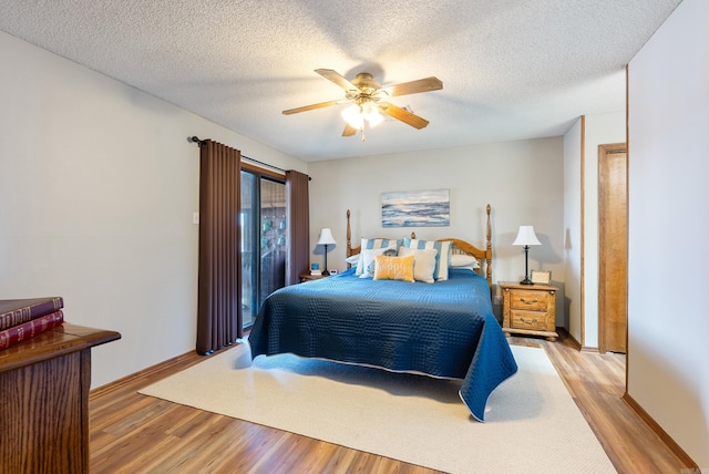 bedroom featuring light wood-type flooring, ceiling fan, a textured ceiling, and baseboards