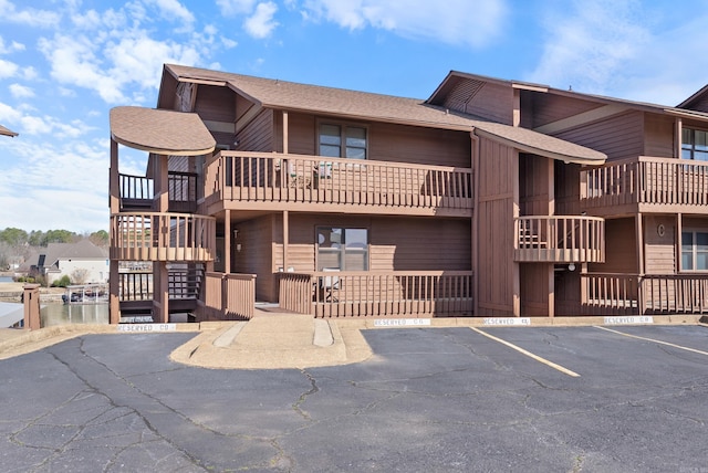 view of building exterior with uncovered parking and stairs