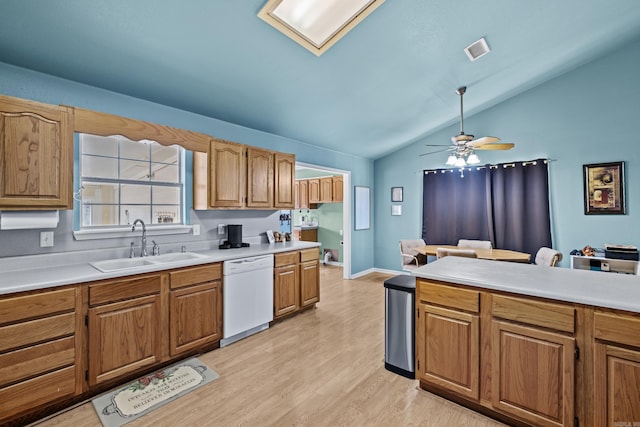 kitchen featuring white dishwasher, light wood-style flooring, a sink, visible vents, and light countertops