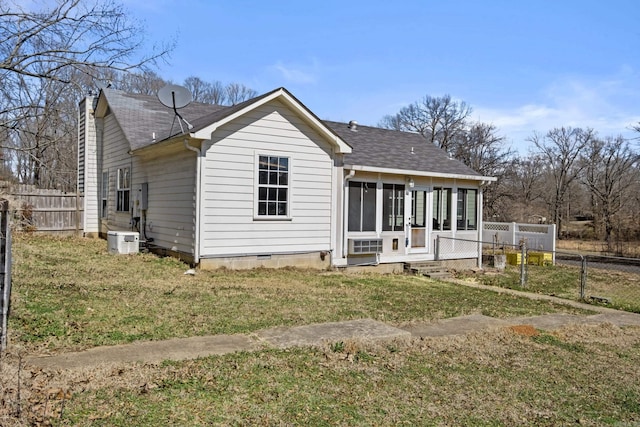 view of front facade with a sunroom, crawl space, fence, and a front lawn