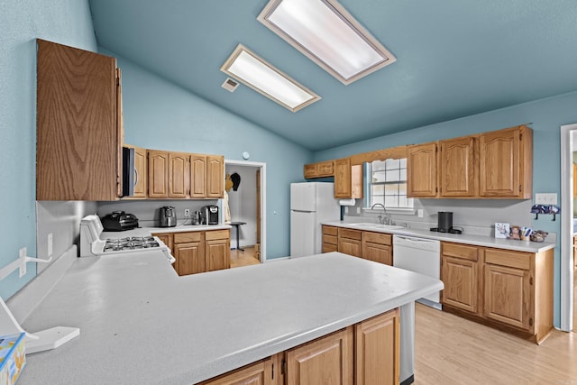 kitchen with lofted ceiling, light countertops, visible vents, a sink, and white appliances