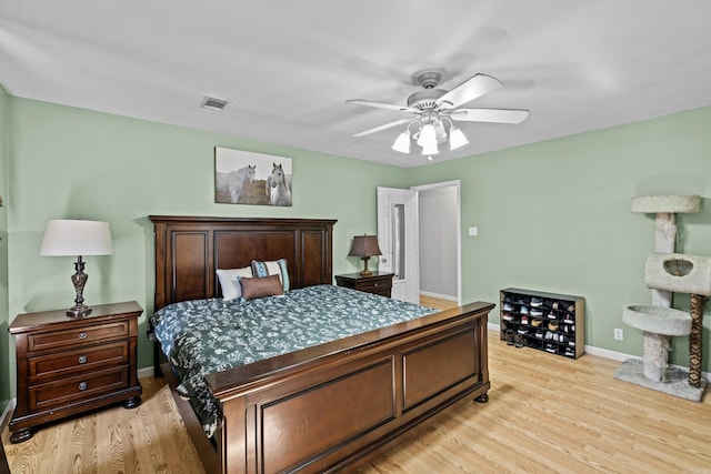 bedroom with light wood-style floors, baseboards, visible vents, and a ceiling fan