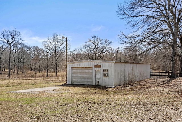 detached garage featuring fence and driveway