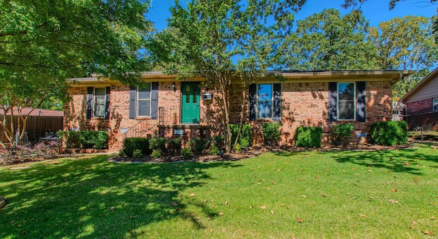 ranch-style house featuring a front yard, fence, and brick siding