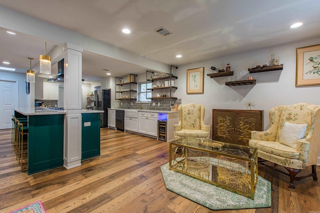 kitchen with open shelves, light countertops, visible vents, white cabinetry, and hardwood / wood-style flooring