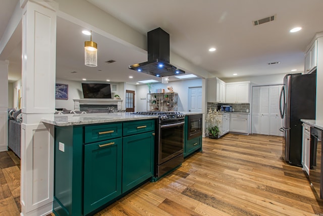 kitchen with island range hood, visible vents, appliances with stainless steel finishes, and green cabinetry