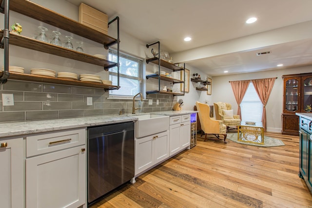 kitchen with open shelves, a sink, visible vents, and light wood-style floors